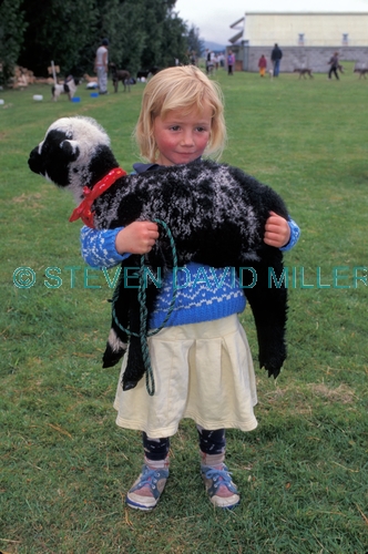 little girl holding pet;little girl holding lamb;school fete;new zealand girl;girl in new zealand.