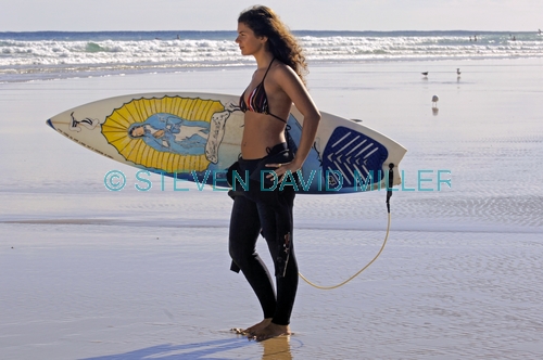 woman on surfboard;woman surfer;woman lying on surfboard;woman paddling surfboard;byron bay surfer